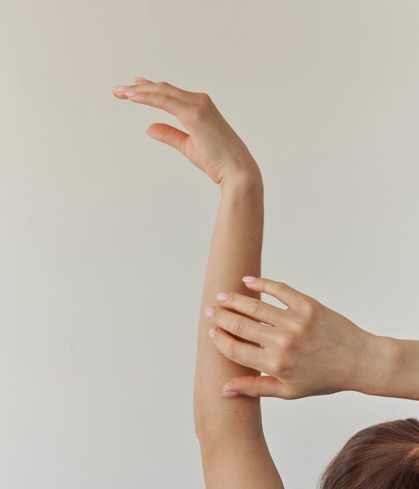 Woman in a graceful yoga pose on a mat with light streaming in.